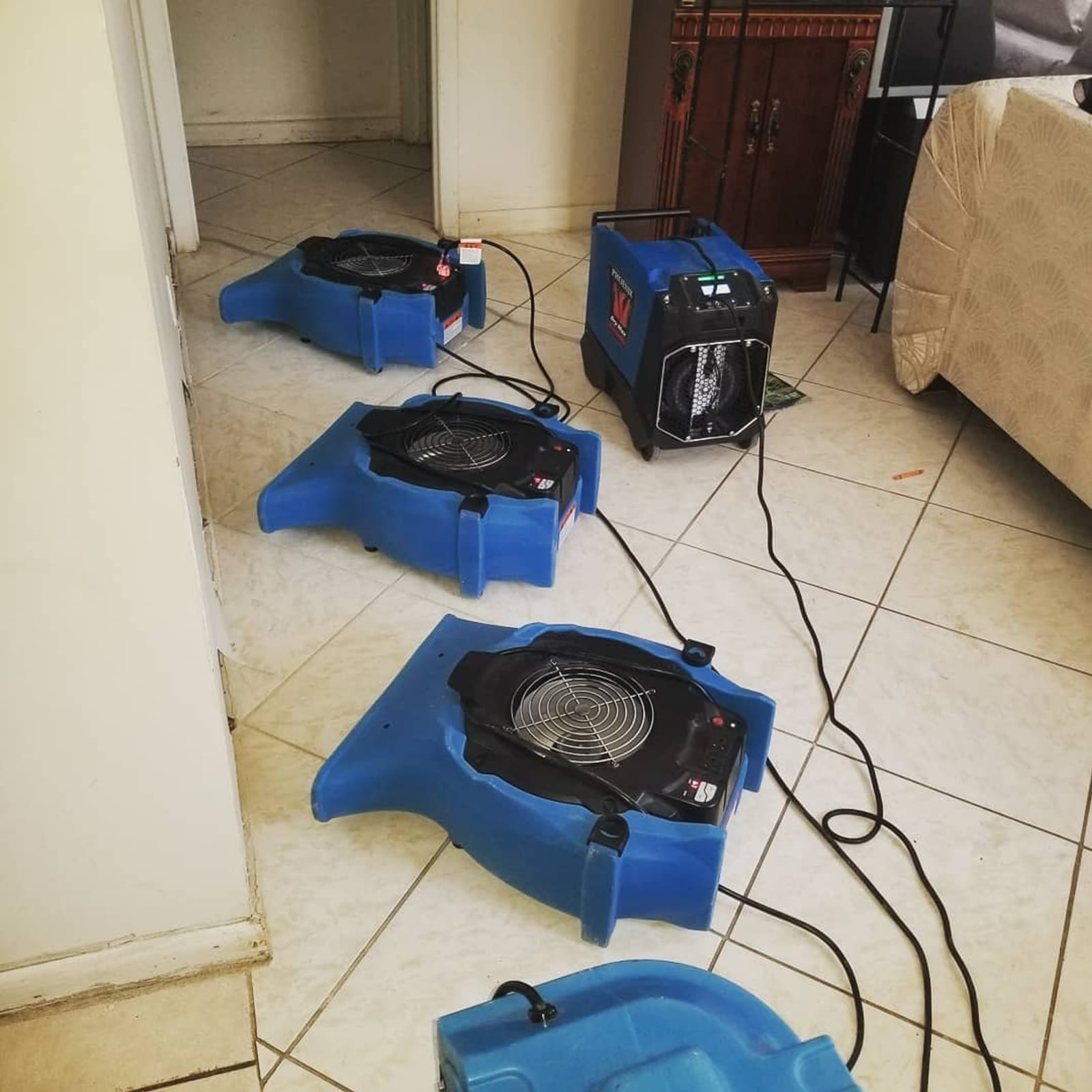 Industrial air movers and dehumidifier set up for water damage mitigation